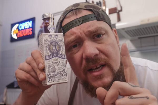 nick toet met een fles raijmakers heetmakers hot sauce in zijn handen